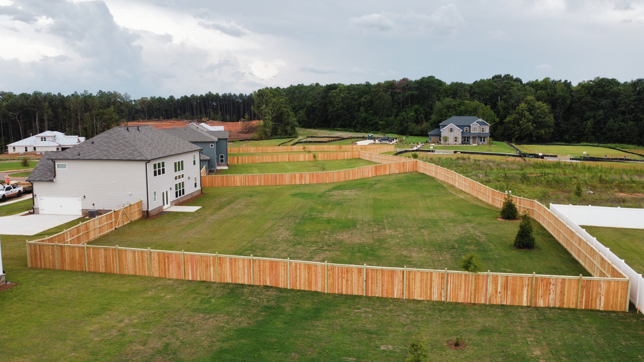 Contractor welding a damaged chain link fence at a commercial site