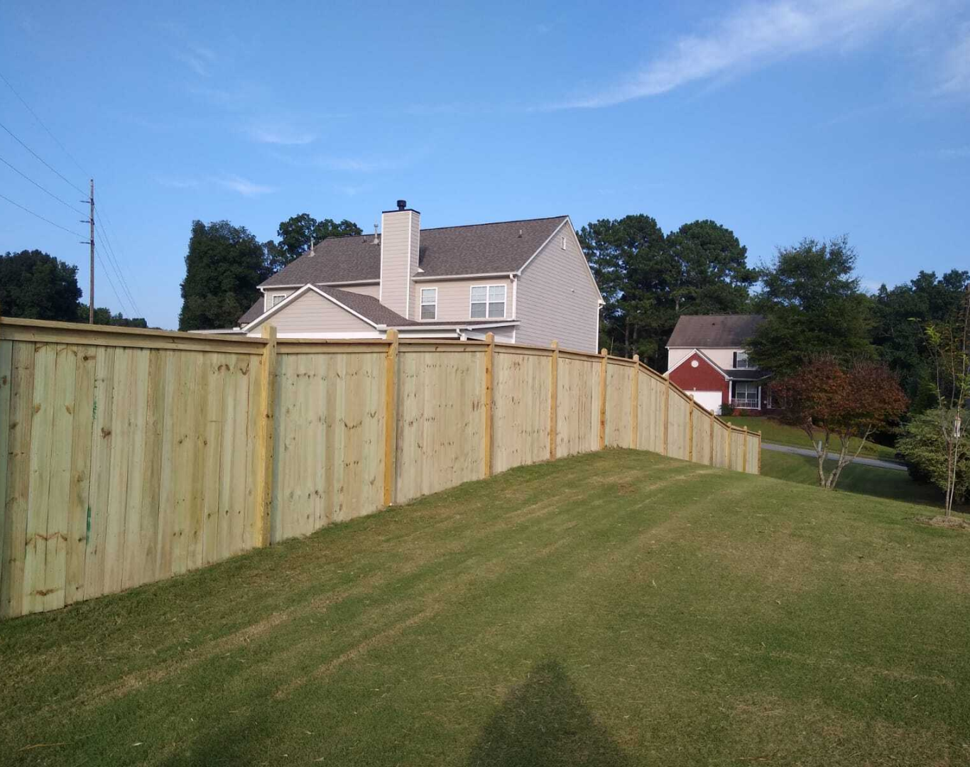 Contractor welding a damaged chain link fence at a commercial site